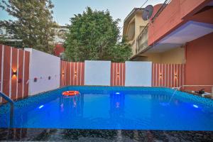 a large blue swimming pool in front of a fence at ll EMPYREAN STAY ll 2BHK ll LUCIFER VILLA ll AC ll PRIVATE POOL ll in Lonavala +18 photos