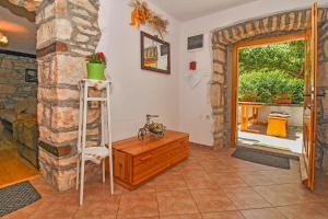 a living room with a wooden cabinet and a stone wall at Erika in Šumber (Haus für 4-6 Personen) in Nedeščina