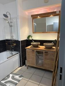 a bathroom with two sinks on a counter with a shower at Evasion du Lagon in Saint-Pierre