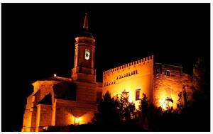 a large building with a clock tower at night at Calatorao apartamentos in Calatorao