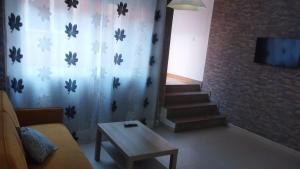 a living room with a staircase and a couch and a table at Calatorao apartamentos in Calatorao