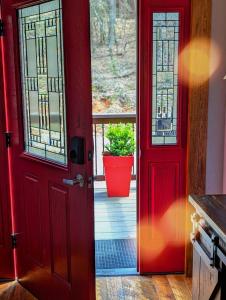 an open red door with a potted plant on a porch at Serene mountain cabin with hot tub and 2 ensuites in Stephens Gap
