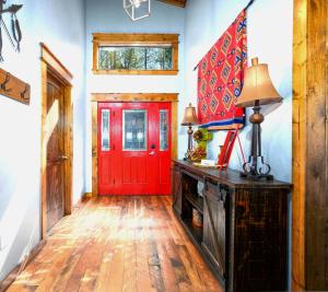 a red door in a room with a wooden floor at Serene mountain cabin with hot tub and 2 ensuites in Stephens Gap +65 photos
