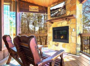 a porch with two chairs and a stone fireplace at Serene mountain cabin with hot tub and 2 ensuites in Stephens Gap