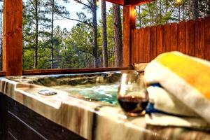 a hot tub with a glass of wine in it at Serene mountain cabin with hot tub and 2 ensuites in Stephens Gap