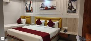 瓦拉纳西Shree Shanteshwar Mahadev Inn的酒店客房设有两张床,墙上挂有照片