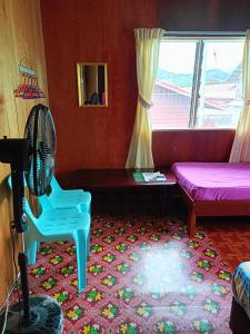 a room with a fan and a couch and a window at Bulan And Daud Homestay in Bario