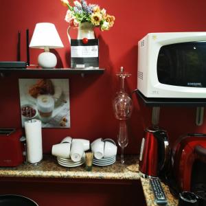 een aanrecht met een magnetron en een tafel met servies bij Fortress Twin Room in Braşov