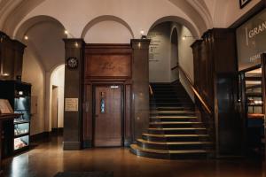 a hallway with a door and stairs in a building at Home Hotel Grand Helsingborg in Helsingborg