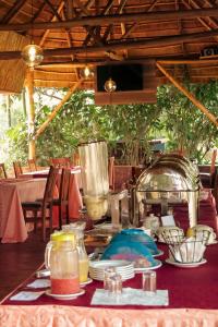 einen Tisch mit Teller mit Speisen darüber in der Unterkunft Nile Bridge Cottages in Jinja