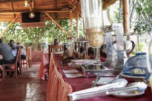 einen Tisch mit einem roten Tischtuch mit Futter drauf in der Unterkunft Nile Bridge Cottages in Jinja + 56 Fotos