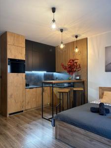 ein Schlafzimmer mit Bett und eine Küche mit Theke in der Unterkunft Apartament Kozigród in Tczew