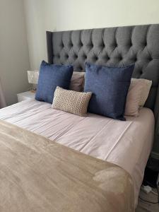 a large bed with two blue pillows on it at Avalon in Stellenbosch
