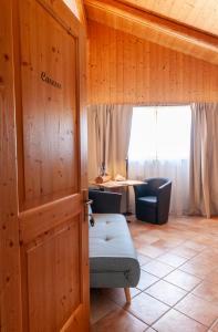 a room with a door with a couch and a table at Chalet Chapeau RaR in Castel Condino