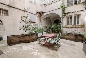 a table and chairs in front of a building at Maison des Moines Terrasse & Confort in Valence