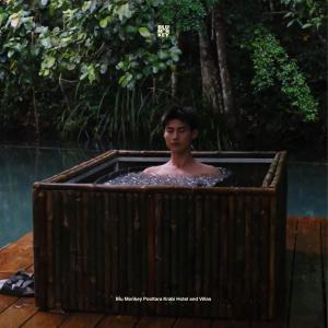 a man in a bath tub in the water at Blu Monkey Pooltara Krabi Hotel & Villas Pet Friendly in Tha Lane Bay