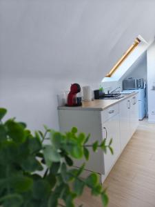 Una cocina con gabinetes blancos y encimera. en Cosy Studio, en Quimperlé