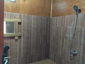 una ducha con cabezal de ducha en un baño en Senaru Lodge, en Senaru