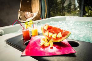 a slice of watermelon on a tray in a bath tub at Chambres d'hotes Deluxe Jacuzzi Mas de l'Etoile in Aigues-Mortes