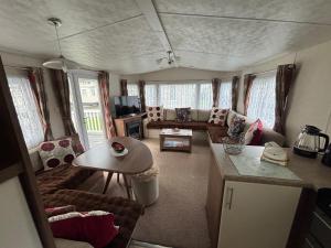 a living room with a couch and a table at Modern 2017 model Delta Sienna static caravan in Clarach Bay in Aberystwyth