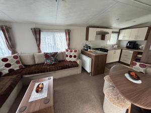 a living room with a couch and a table at Modern 2017 model Delta Sienna static caravan in Clarach Bay in Aberystwyth