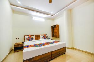 a bedroom with a large bed in a room at Hotel Alaknanda Paradise in Dehradun +5 photos