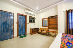 a bedroom with a bed and a desk and a window at Hotel Alaknanda Paradise in Dehradun