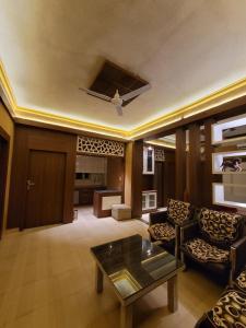 a living room with a couch and a table at Hotlel Sanjivani Salasar in Juliāsar