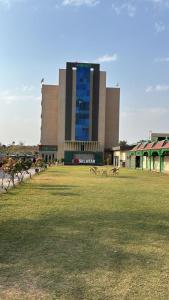 a large building with two benches in a field at Hotlel Sanjivani Salasar in Juliāsar +5 photos