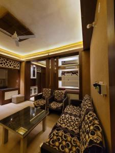 a living room with a couch and a table at Hotlel Sanjivani Salasar in Juliāsar