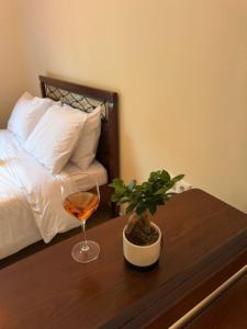 einen Tisch mit einem Glas Wein und einer Topfpflanze in der Unterkunft Arachova Comfort in Arachova