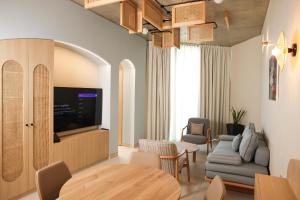a living room with a tv and a table and chairs at Inanna Resort in Batroûn
