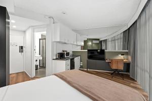 Un dormitorio con una cama grande y una cocina. en Madison Tower Mill Hotel, en Brisbane