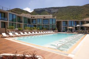 a swimming pool with lounge chairs and a hotel at Inanna Resort in Batroûn