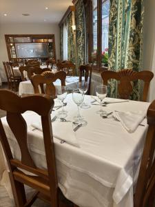 a dining room with a table with wine glasses at Hotel Soldeu Maistre in Soldeu
