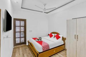 a bedroom with a bed with red and white pillows at Hotel O JANGPURA INN in New Delhi