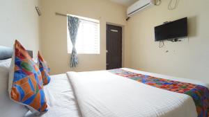 ein Schlafzimmer mit Bett und Flachbildfernseher in der Unterkunft Union Rooms in Coimbatore