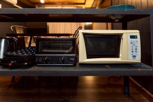 a microwave and a toaster oven on a shelf at Cabin Build Take - 竹 in Biei