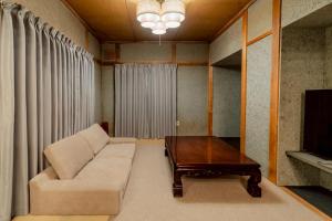 a living room with a couch and a coffee table at Cabin Build Take - 竹 in Biei