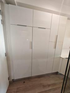 a white closet with white cabinets in a room at Cosy Regency menylin apartment in Pretoria