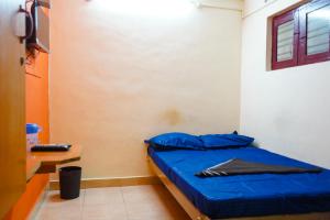 a bedroom with a bed with blue sheets and a desk at Sri Uduppi Lakshmi Vilas Hotel in Madurai