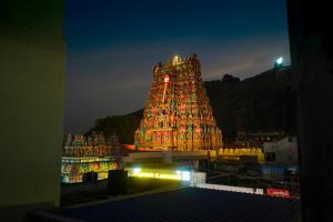 a large building with a lit up tower at night at Sri Uduppi Lakshmi Vilas Hotel in Madurai