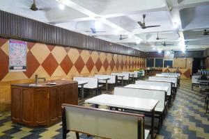 a dining room with white tables and chairs at Sri Uduppi Lakshmi Vilas Hotel in Madurai