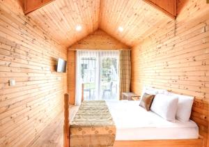 Un dormitorio con una cama en una pared de madera. en Maya World Didyma Hotel - Ultra All Inclusive, en Didim 76 fotos más