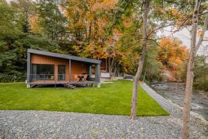 a small house in the woods with a river at River Escape Retreat & Spa - Adults Only in Avrig