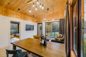 a dining room and living room with a wooden ceiling at River Escape Retreat & Spa - Adults Only in Avrig