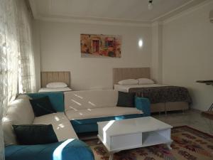 a living room with a couch and two beds at Derin park otel in Sanlıurfa