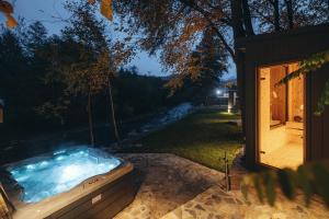 a hot tub in a yard next to a house at River Escape Retreat & Spa - Adults Only in Avrig