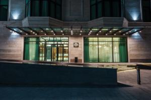 a building with a lit up facade at night at Olive Boutique Hotel in Almaty
