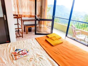 a bedroom with a bed with a view of a balcony at Awinco Rest Inn in Haputale